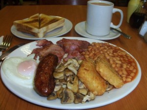 É o famoso Full English breakfast, onde não falta feijão, salsichas, bacon, ovos, cogumelos, hash browns (uns bolinhos de batata fritos), torradas, além do tradicional chá inglês, oras (Foto: Divulgação)